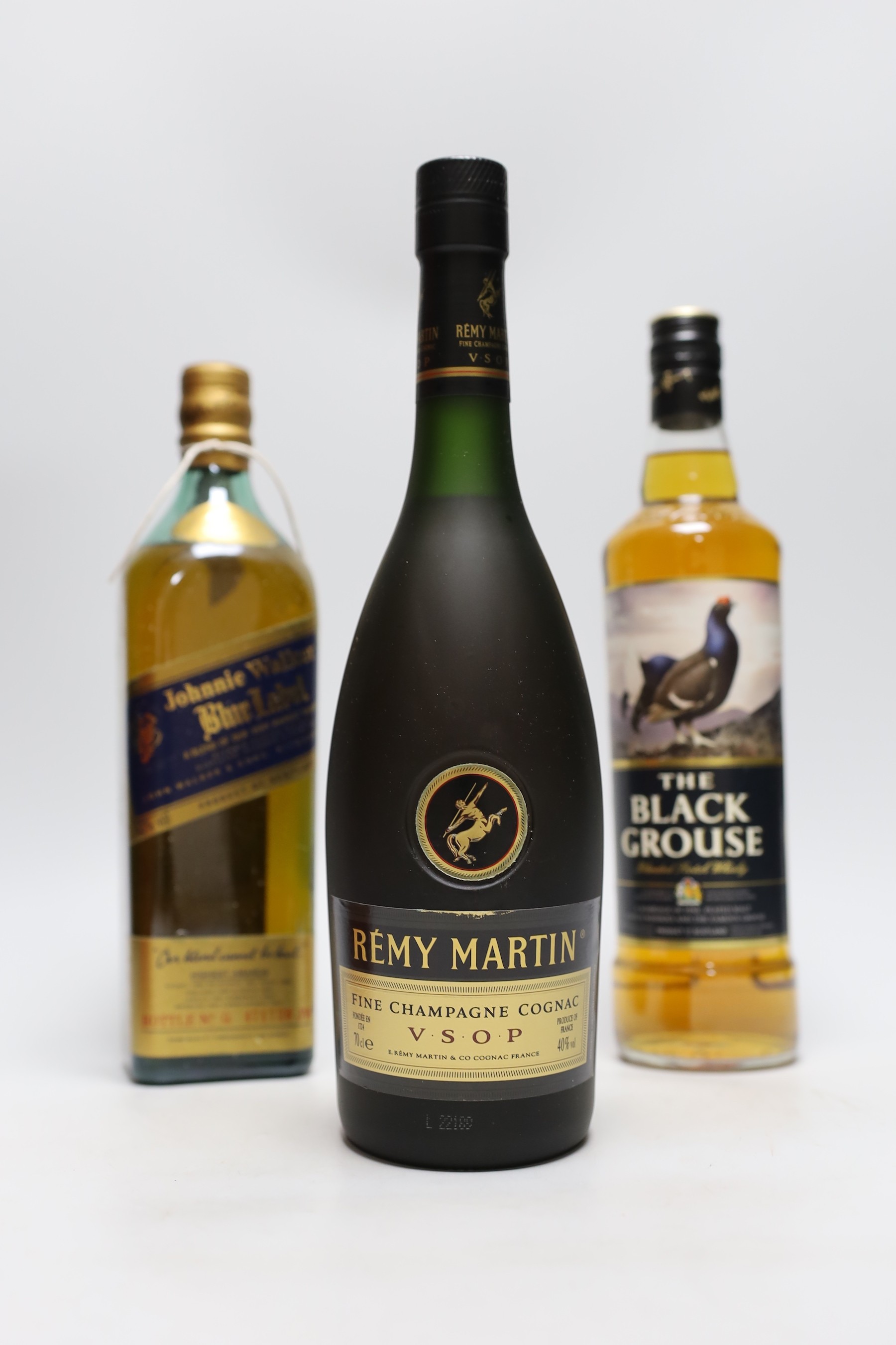 A cased 70cl bottle of Remy Martin, a bottle of Johnnie Walker blue label and a bottle of The Black Grouse